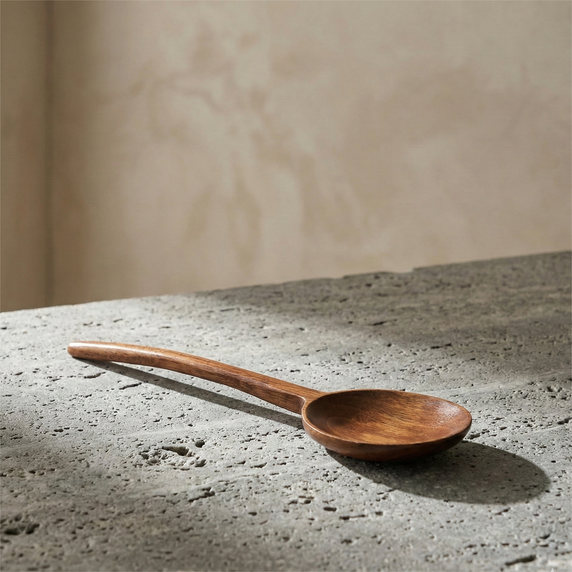 A natural Phoebe wood cooking spoons laid on cream linen fabric
