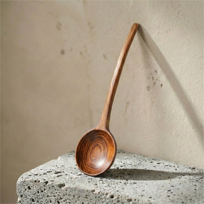 A natural Phoebe wood cooking spoons laid on cream linen fabric