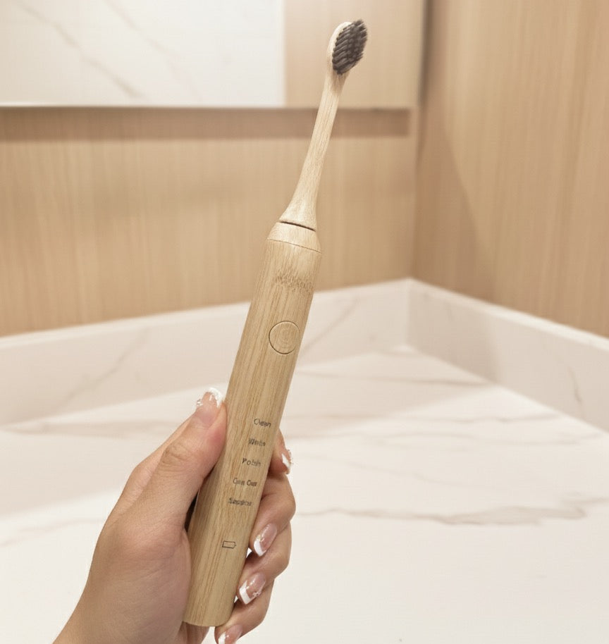Hand holding a ZenBrush bamboo electric toothbrush showing the bamboo brush head