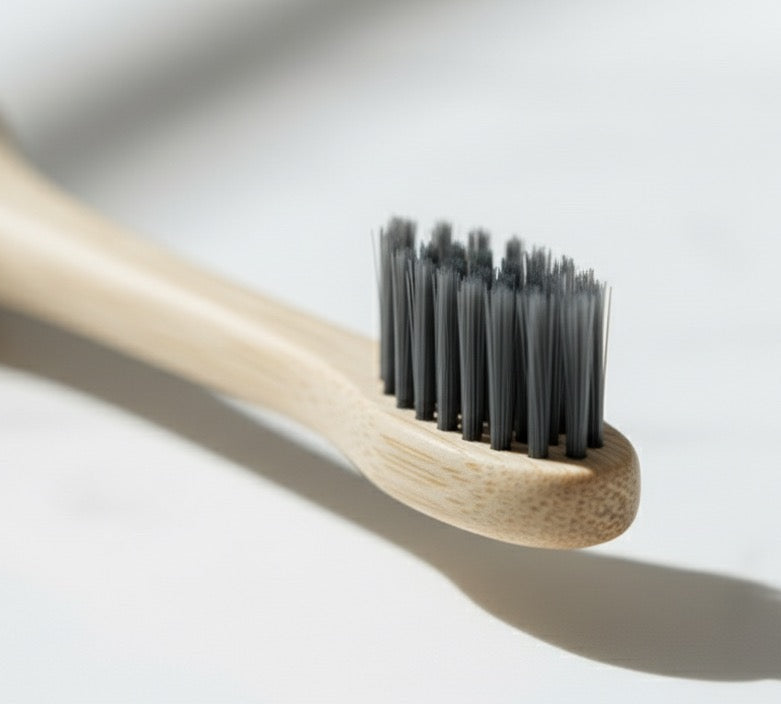 Kewevia Bamboo toothbrush with black bristles on a light gray background