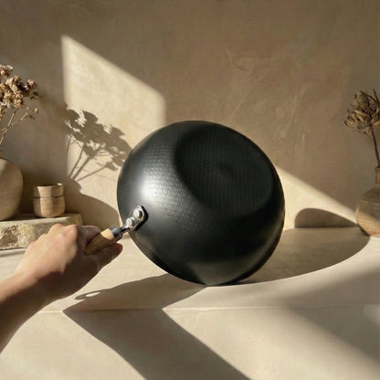 22cm nitride iron Solo Wok placed on a concrete shelf viewed from the side