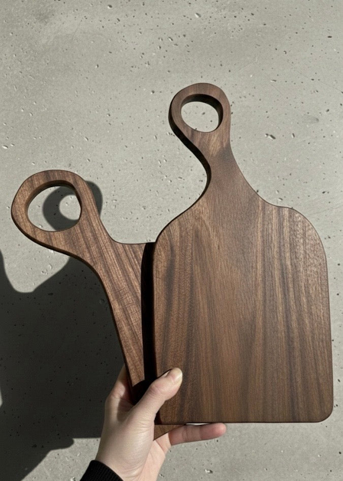 Top-down view of two black walnut cutting boards showing size difference and natural grain pattern